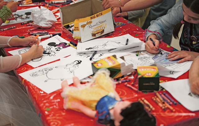 Children color cartoon characters during the arts and crafts portion of the opening. 