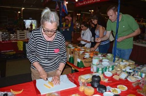 Jacobina Kosman, a vendor from the Old Dutch Cheese Company, cuts pieces of fresh gouda for customers to sample.