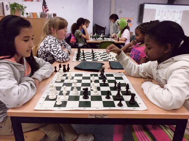 Photo by Jack WoodforkVogelweh Elementary School fifth-grader Kathleen Julca (foreground, left) plays Kaiserslautern Elementary School fourth-grader Heaven Jones (foreground, right) in a game of chess as a way to prepare for a tournament Feb. 22 at the KMCC.