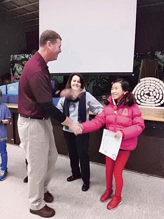 Courtesy photoWilliam Walker, the representative for VFW Post 2560 in Baumholder, and Wetzel Elementary School Principal Angie Lamonski (center) present WES sixth-grader Yeji Lee with a certificate, medal and $75 college fund check for winning second place in the annual Patriot’s Pen Essay competition.