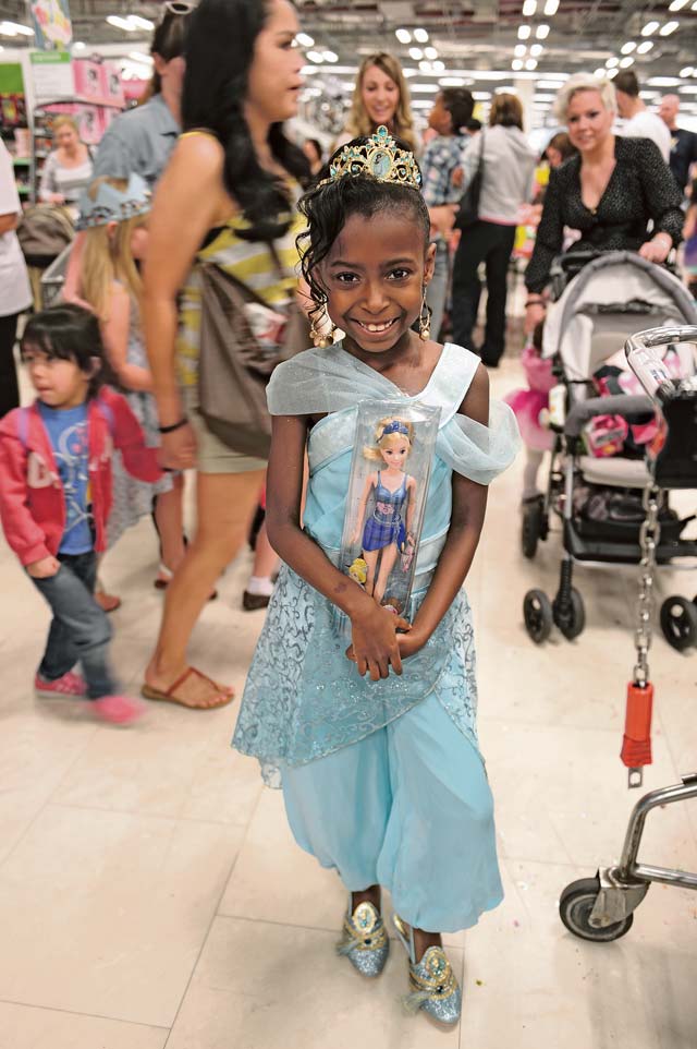 Mackenzie Harris, daughter of Agnes Cooper and U.S. Army Sgt. Edward Cooper, 5th Quartermaster Company, is dressed as a princess as she stands with a doll during the opening of a toy collection. This is the first time the toy collection was offered on Ramstein and is  only available in a few exchanges around the world.