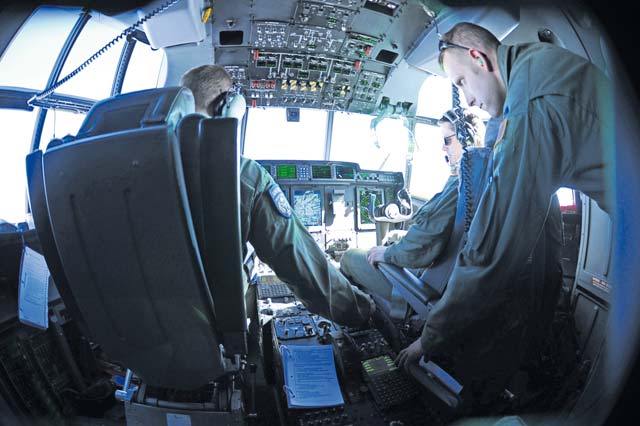 Capt. Christopher Boelscher (left), Maj. Dennis Hamilton (middle) and Capt. Matthew Schoomaker (right), 37th Airlift Squadron pilots, work together to fly more than 20 Airmen to Romania April 14 to participate in Exercise Carpathian Spring. The exercise was designed for aircrew to train as well as help build a partnership capacity with Romanians.