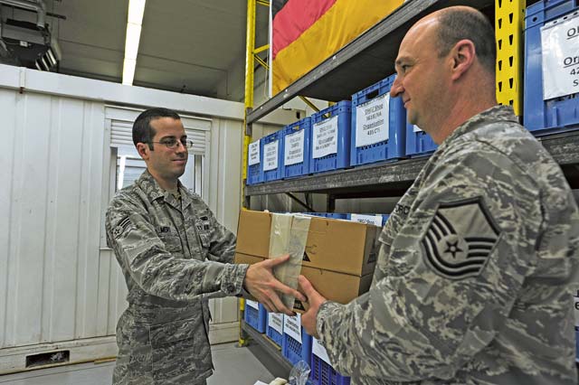 Senior Airman Andrew Mero, 86th Logistics Readiness Squadron individual equipment element technician, issues Master Sgt. Kenneth Pruett, 86th LRS unit deployment manager, boots for a deploying troop Jan. 21 on Ramstein. 
