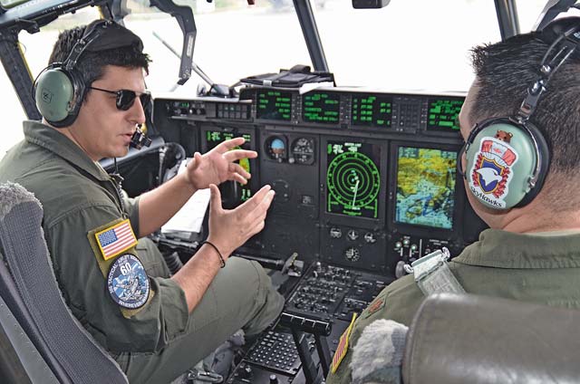 Photo by Tech. Sgt. Chris BirdwellGreek Capt. Vasileios Mosios, 356th MTM (Tactical Transport Squadron) co-pilot, discusses the functions of a C-130J Super Hercules with Maj. Bill Tice, 37th Airlift Squadron instructor pilot, during Stolen Cerberus, a flight training deployment Feb. 2 to today designed to incorporate various training methods in order to maintain proficiency during deployed operations and increase interoperability with the Hellenic air force. 