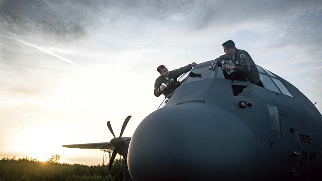 U.S. Air Force Maj. Jeff Bliss (right) and Capt. Brett Polage, 37th Airlift Squadron pilots, wash the windows of a C-130J Super Hercules at Riga International Airport, Latvia, after air dropping American and Lithuanian service members over Lithuania May 17.