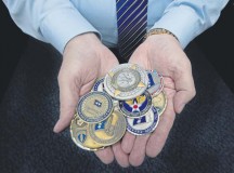 John Mace, 86th Medical Group special operations medical officer, holds a handful of coins he has collected throughout his 54 years in the military Dec. 8 on Ramstein. Mace is scheduled to retire today after spending 25 years in active duty and 29 more in civil service.