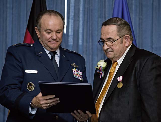 Photo by Senior Airman Jonathan StefankoGen. Philip M. Breedlove, commander of U.S. European Command and Supreme Allied Commander Europe, and John Mace read a certificate of service during Mace’s retirement ceremony Dec. 12 on Ramstein. Mace retired from the military after 25 years and retired again from civil service after 29 years.