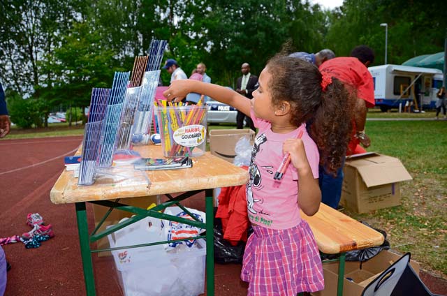 Keidy Benitez reaches for pencils located at the Army Substance Abuse Program information table during the U.S. Army Garrison  Kaiserslautern Night Out event Aug. 8 at Pulaski Park. 