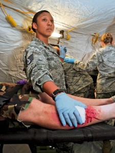 A medical unit member patches up the leg of a wounded patient