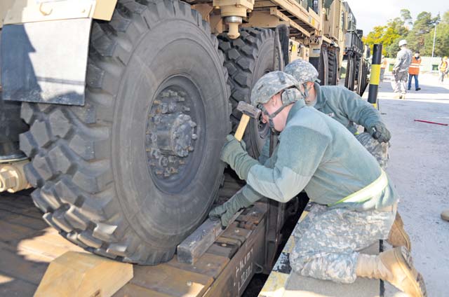 Soldiers from the 5th Battalion, 7th Air Defense Artillery Regiment, 10th Army Air and Missile Defense Command brace a vehicle on a railcar during a logistical exercise Oct. 16 on Rhine Ordnance Barracks.