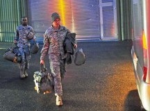 Two paratroopers assigned to the 21st Theater Sustainment Command’s 5th Quartermaster Detachment carry their parachutes to a bus bound for Ramstein Nov. 7.