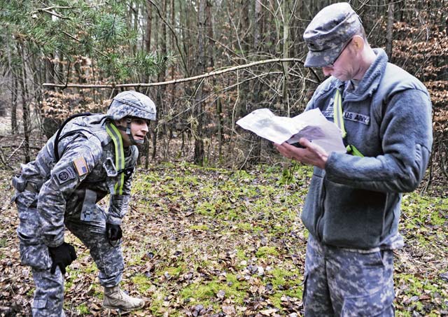 Sgt. Noel Phelps (left), parachute rigger with the 21st Theater Sustainment Command’s 5th Quartermaster Company (Riggers), 21st Special Troops Battalion, catches his breath while Sgt. Matthew Langton, 5th QM Co. parachute rigger, grades the results of the land navigation portion of the Best Warrior Competition.