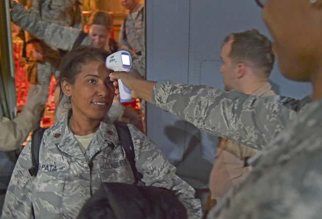 Maj. Mayra Zapata, 633rd Medical Operations Squadron, gets her temperature taken by Tech. Sgt. Saquadrea Crosby, 86th Aerospace Medicine Squadron public health NCOIC, as she deplanes a C-130J Super Hercules Oct. 19 on Ramstein. Any personnel traveling into Ramstein from Ebola infected areas will be medically screened upon their arrival and cleared by public health for onward travel to ensure the health and safety of all passengers, aircrew and members of the KMC.
