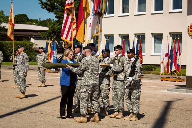Photo by G. Patrick HarrisKathleen Y. Marin, Installation Management Command-Europe director, and Command Sgt. Maj. Jeffrey S. Hartless uncase the IMCOM-E colors during a ceremony June 6 at Sembach Kaserne. The command moved to Sembach from Heidelberg as part of the ongoing U.S. Army transformation in Europe.