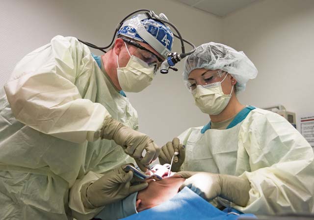 Maj. Curtis Hayes (left), 86th Dental Squadron chief oral and maxillofacial surgeon, and Senior Airman Britanni McKnight,  86th DS dental assistant, operate on a patient during a dental implant surgery April 29 on Ramstein.