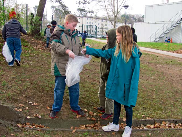 Photo by Debra Crenshaw From left, Vogelweh Elementary School fourth-graders Jacob Queen, Logan Cooper and Ashley Bronner do their part during an Earth Day clean-up drive around the school.