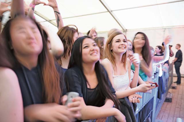 A fan gazes from the crowd as 3OH!3 performs during a free concert hosted by Armed Forces Entertainment.