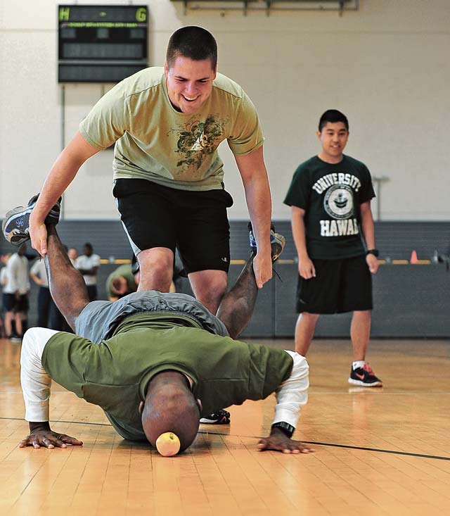 Justin Anderson wheel barrels his  teammate, Aaron Banks, across the finish line in a relay.