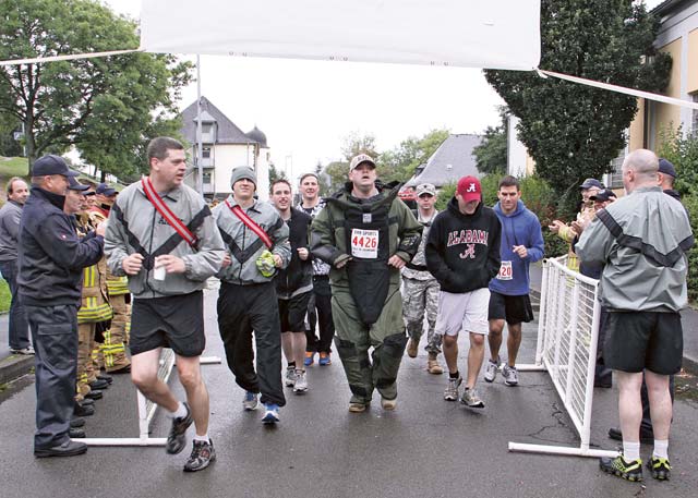 Photo by Bernd MaiStaff Sgt. Derek Hillmer, 720th Explosive Ordnance Disposal Company, crosses the finish line wearing a 75-pound bomb suit during Baumholder’s 9/11 Remembrance Run Sept. 11.