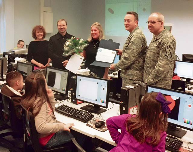Photo by Andy MendozaStudents watch as Brig. Gen. Patrick X. Mordente (second from right), 86th Airlift Wing commander, presents Sarah Loomis (third from left) with the Teacher of the Year award for the Kaiserslautern District.