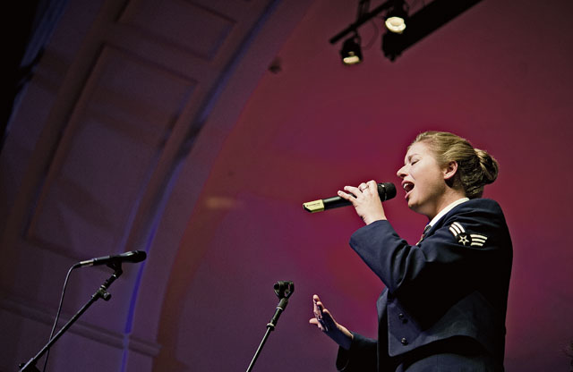 Senior Airman Carmen Emborski, U.S. Air Forces in Europe and Air Forces Africa Band vocalist, belts out holiday classics with her unique vocal style during the KMC Holiday Concert Dec. 13. The band spends most of the season spreading joy through music, and this annual concert is one of their most popular performances in the KMC.