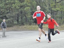 Photo by Senior Airman Timothy MooreMaj. Francisco Patino, NATO Allied Air Command, is joined by his son as he nears the finish line of the Ramstein Air Base Half Marathon Sept. 13. More than 300 members of the KMC participated in the half marathon.