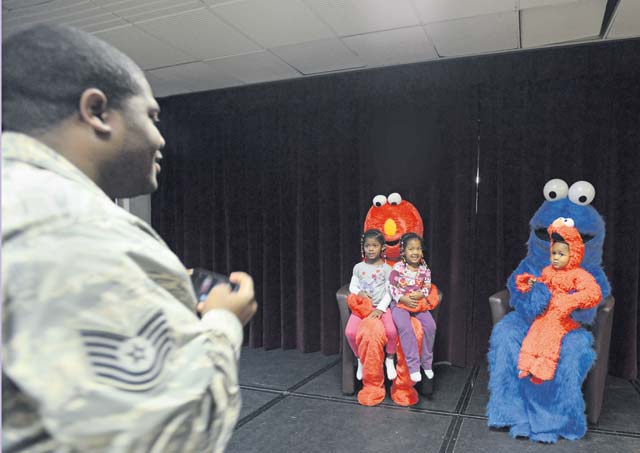 Tech. Sgt. Andre Grant, U.S. Air Forces in Europe and Air Forces Africa, takes a photo of his children with Elmo and Cookie Monster during a family night hosted by the Ramstein Community Center Sept. 22. 