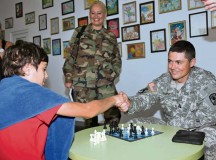 Photo by Sgt. 1st Class Matthew ChlostaCapt. Dave Esra, commander of Headquarters and Headquarters Company, 361st CA Brigade, 7th Civil Support Command, shakes hands with Cristian Trocin, of Dcochia City, Moldova, after a chess match Sept. 11 at Moldova’s National Children Rehabilitation Center in Ceadir-Lunga, Moldova.