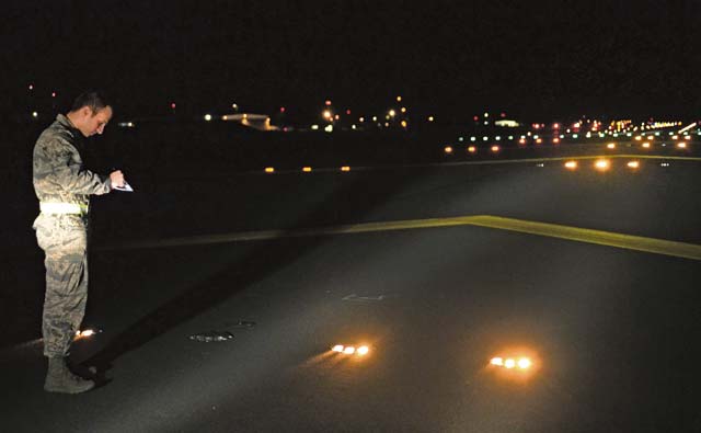 Photo by Senior Airman Caitlin Guinazu Airman Brandon Horning, 86th Operations Support Squadron airfield management operations coordinator, inspects and records the location of malfunctioning lights on the airfield, July 31 on Ramstein. The 86th OSS airfield management flight works around the clock to ensure the airfield is a safe and operational environment. 