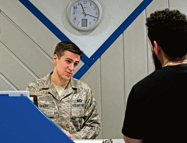 Senior Airman Andrew Shodi, 786th Force Support Squadron fitness specialist, interacts with a fitness center visitor Jan. 21. The Northside Fitness Center has implemented new hours, allowing people to use workout equipment from 4 a.m. Monday to midnight Friday.