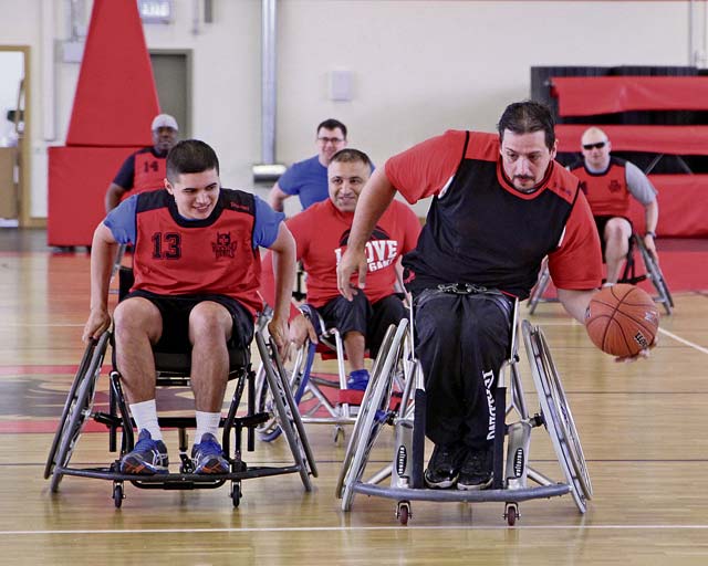 Photo by Linda SteilWarrior Transition Battalion-Europe Soldier Spc. Israel Cruz chases Bundesliga FCK Rolling Devils wheelchair basketball player Sascha Gergele down the court during a friendly game May 30 at the Kleber Fitness Center.