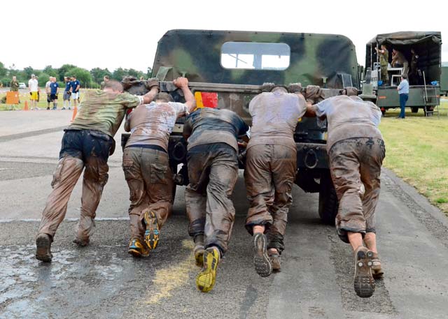 A team pushes a HUMVEE to the finish line. The HUMVEE push was the last obstacle of the competition and one of the most difficult.