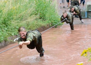 German soldiers use a cable to carefully slide over a water obstacle without falling in. Regardless if you made it across or not, dismounting from the cable meant a splash in the water.