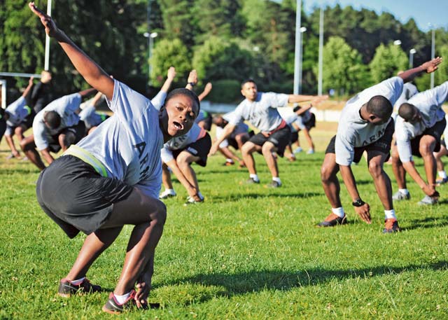 Staff Sgt. Juna C. Cyriaque, personnel NCO assigned to the  21st Theater Sustainment Command’s Special Troops  Battalion, leads her class in performing “The Windmill” during Physical Readiness Training as a part of the Master Fitness Trainer course June 24 on Vogelweh.
