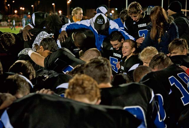 The Hohenfels Tigers pray together after winning the championship game. Behind 35-18, the Tigers scored three touchdowns in the fourth quarter to claim victory over the SHAPE Spartans.
