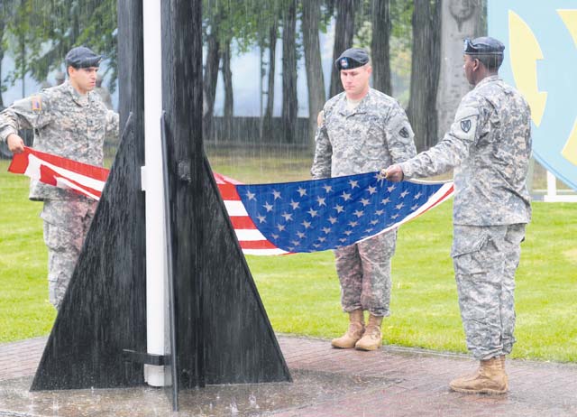 Photo by Brandon BeachUnder heavy rain, Soldiers from the 21st Theater Sustainment Command pay respect to the U.S. flag during a 9/11 remembrance ceremony Sept. 11 on the Panzer Kaserne Parade Field.