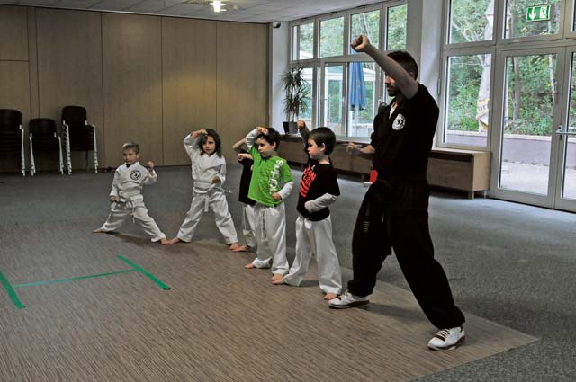 Karate Tech class instructor Jorge Ordonio Jr. does karate moves with KMC children Oct. 8 on Vogelweh.