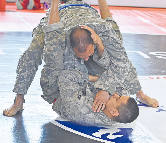 Photos by Airman Dymekre AllenAirman 1st Class Kazuhito Ikematsu, 1st Combat Communications Squadron radio frequency transmissions technician, attempts a triangle choke hold during the combatives tournament.