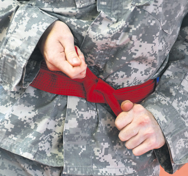 Pfc. Lisa Manela from Wiesbaden Army Airfield tightens her waist band.