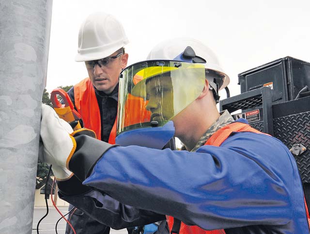 Airman 1st Class Keith Martineau, 786th Civil Engineer Squadron electrical systems journeyman, and Tech. Sgt. Jason Howland, 786th CES NCO in charge of exterior electrical systems, check the circuit in a streetlight before repairing it Aug. 15 on Ramstein. The night operations crew repaired and replaced more than 500 lights during a three-week effort.