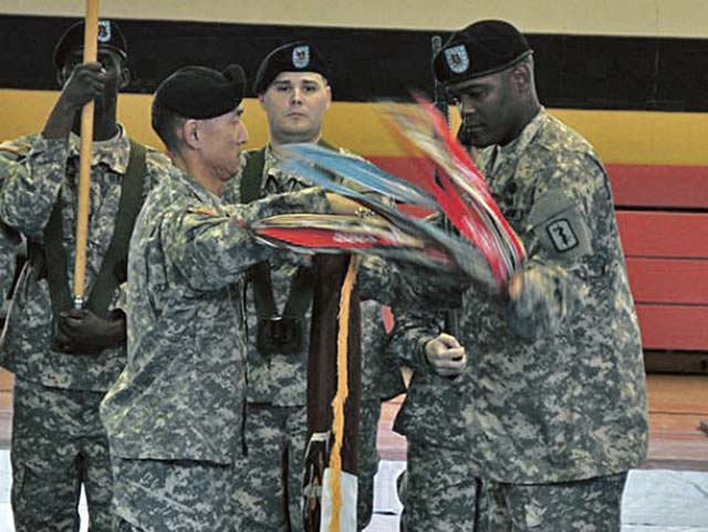 Photo courtesy of the U.S. ArmyCol. Koji D. Nishimura (left) and Command Sgt. Maj. George W. Grace Jr. (right), the commander and command sergeant major of the 30th Medical Brigade, uncase the 30th Med. Bde. colors during a ceremony Oct. 18 on Sembach Kaserne.  The unit re-designated from a command to a brigade as part of ongoing changes to the Army’s organizational structure and is now a subordinate unit of the 21st Theater Sustainment Command. 