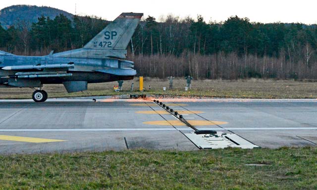 Photo by Airman 1st Class Michael StuartAn F-16 assigned to Spangdahlem Air Base, Germany, runs through a test of a Barrier Arresting Kit-12 Jan. 28, 2014, on the Ramstein flightline. Safeguarding equipment and the lives of military personnel, the BAK-12 ensures a safe deceleration of landing aircraft within a few seconds. 