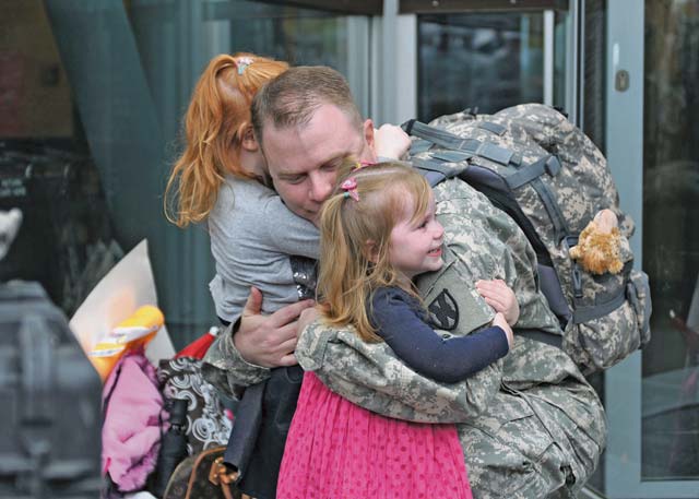 Maj. Gavin Luher, disbursing officer with the 21st Theater Sustainment Command’s 266th Financial Management Support Center, is greeted by his family Oct. 7 after returning from a nine-month deployment to Kuwait.