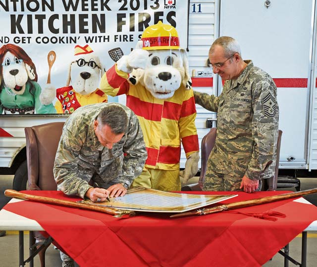 Photo by Airman 1st Class Michael StuartBrig. Gen. Patrick X. Mordente (left), 86th Airlift Wing commander, and Chief Master Sgt. James Morris, 86th AW command chief, sign the 2013 Fire Prevention Week Proclamation Oct. 4 on Ramstein. This year’s theme of Fire Prevention Week is to stress the dangers of kitchen fires.