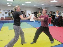 Courtesy photoJackie Richard, a self-defense seminar student, uses the techniques she learned to break a board held by instructor Michael Grimes. Ramstein Family Advocacy hosted self-defense seminars 
Oct. 3 to help increase awareness about intimate partner violence. For more information about self-defense seminars and future dates in spring, call Family Advocacy at 479-2370 or 06371-46-2370.