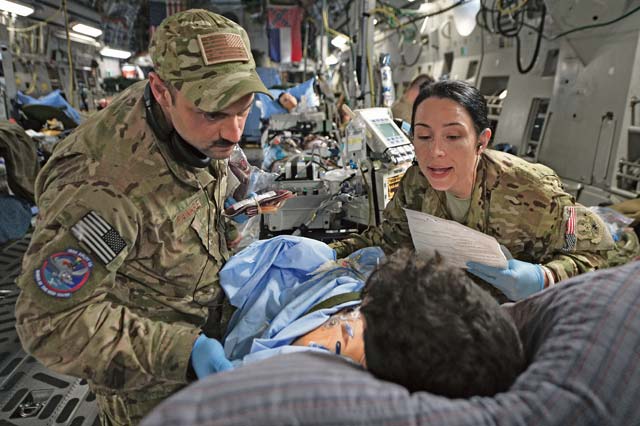 Capt. Mario Ramirez and Capt. Suzanne Morris, members of the 455th Expeditionary Aeromedical Evacuation Squadron Critical Care Air Transport Team, confirm a patient’s identity and prepare to administer a blood transfusion during a flight out of Bagram Airfield, Afghanistan, March 21, 2013.