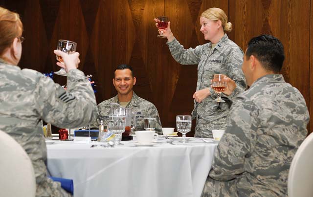 Photo by Airman Larissa Greatwood First Lt. Amara Adams, 39th Air Base Wing chief of protocol at Incirlik Air Base, Turkey, demonstrates how to formally give a toast during the Protocol Fundamental Course simulated retirement luncheon Aug. 1, 2014, at Ramstein Air Base, Germany. The course attendees learned to manage many aspects of protocol to include ceremonies, distinguished visitors and fine dining etiquette. 