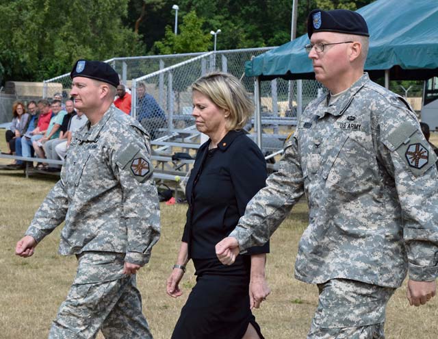 Col. Bryan D. DeCoster (left), outgoing U.S. Army Garrison Rheinland-Pfalz commander; Kathleen Marin, Installation Management Command-Europe region director; and  Col. G. Shawn Wells, USAG Rheinland-Pfalz commander, march onto NCO Field during the garrison’s change of command ceremony June 25 on Daenner Kaserne.