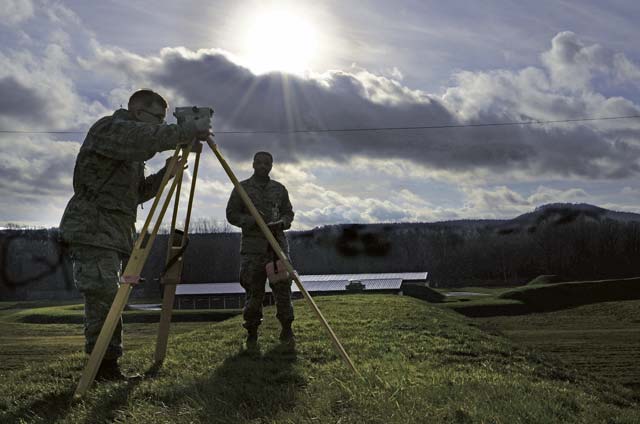 Airman 1st Class Justin Mason, 86th Civil Engineer Squadron engineering assistant, and Senior Airman Dwayne Stewart, 86th CES geobase  technician, use a total station measuring tool to measure the level of protective soil on munition depots Jan. 8 on Ramstein. The Airmen of the  86th CES use geographic information systems to map the entire KMC for the contractors who create blueprints for base development.