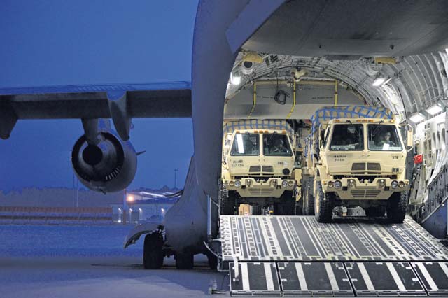Members of the 212th Combat Support Hospital drive three Medium Tactical Vehicles  loaded with part of their 12-bed Early Entry Package onto a C-17 March 11 on Ramstein. Medics using the EEP are capable of treating a dozen service members in any field environment worldwide.